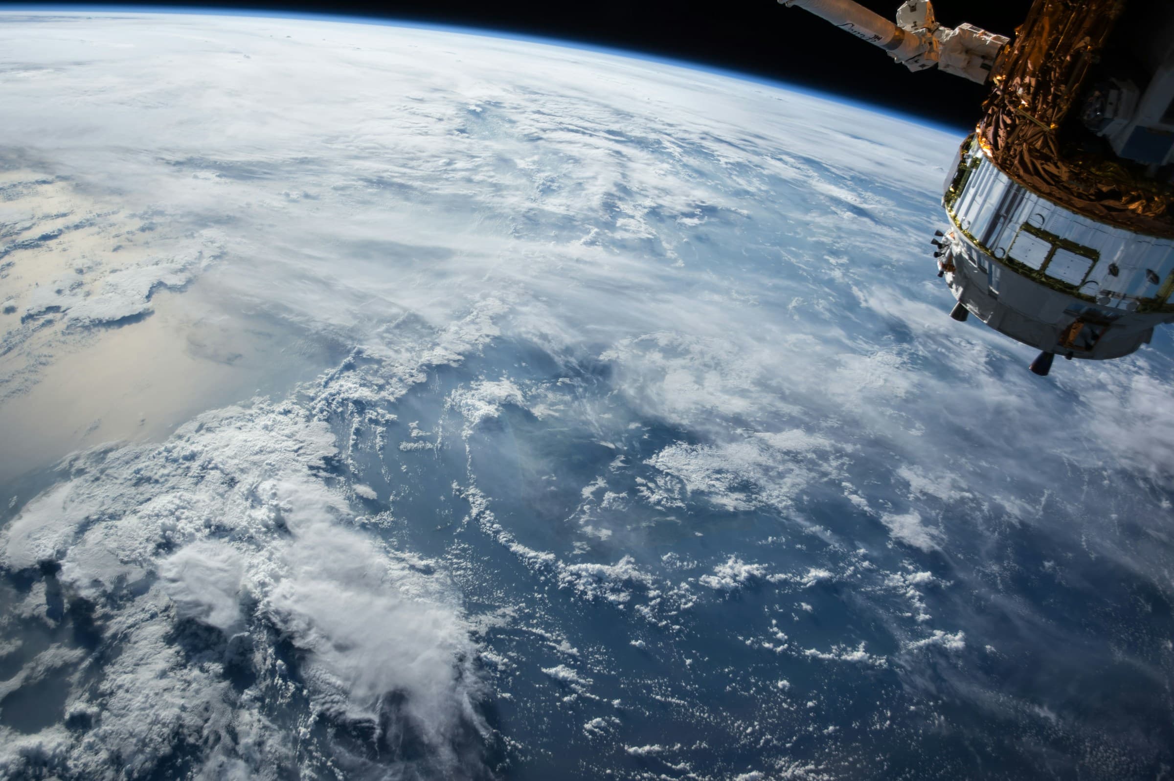 Earth from orbit beside a spacecraft
